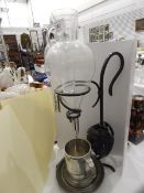 Wine dispenser, the glass body etched with fruiting vines on a metal stand with leaf decoration,