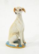 Porcelain model of a seated whippet, on oval base with gilt rim, the base signed 