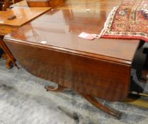 Mahogany fall-flap dining table supported on shaped standards,