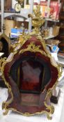 Faux-tortoiseshell clock case with ormolu scrolling mounts and surmounted by a basket of flowers