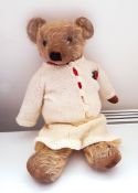 Vintage Merrythought mohair bear with glass eyes wearing a knitted skirt and cardigan,