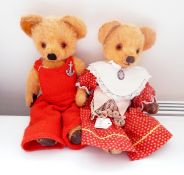 Plush vintage bear wearing knitted dungarees and another in a dirndl style dress with a pendant,