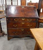 Georgian oak bureau, the fall-front enclosing a fitted interior of small drawers and pigeonholes,