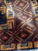 Handmade Eastern wool rug with maroon ground with three central guls surrounded by geometric design,
