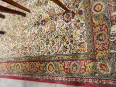 Wool rug, the cream ground with allover stylised floral branch decoration in shades of red,