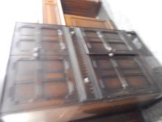 Stained oak side cupboard, the top panelled doors enclosing a cocktail cabinet with mirror back,