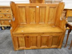 Small pine settle with full panelled back, the hinged box seat enclosing compartment,