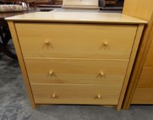 Contemporary pale beech chest of three long drawers, with elegant turned wooden handles,
