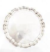 Silver salver by Walker & Hall, Sheffield 1919, of shaped circular form, on three scroll feet,