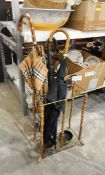 Large Burberry umbrella and two other umbrellas within a bamboo and metal umbrella stand