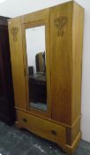 Edwardian wardrobe with bevelled mirror panelled door and with carved ornamentation and drawer to