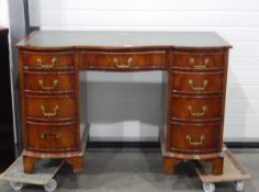 Serpentine-fronted reproduction mahogany kneehole desk, the top inset with green and gilt leather,