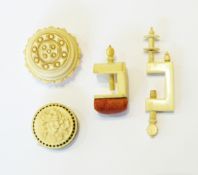 19th century ivory sewing clamp of plain rectangular form and a second of turned circular form with