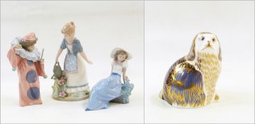 Nao figure of child dressed as a clown, another of girl wearing hat with bird,