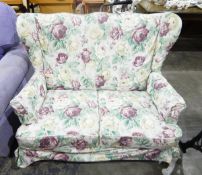 Cottage style wing-side two seat settee with floral patterned loose covers,