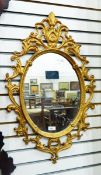 Gilt painted metal oval mirror, 74cm x 46cm approx.