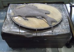 Old tin trunk and wall-mounted fishing tackle hooks with a beaten metal fish