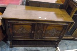 Jacobean-style drop-flap oak cupboard, the pair of lozenge carved panel doors enclosing shelf,