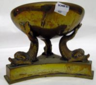 Brass circular bowl on three dolphin-shaped supports and stand,