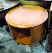 20th century revolving drum-shaped table with inset writing surface and open shelves below,