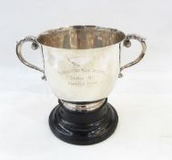 Silver two-handled trophy cup with flared rim on a raised ebonised circular foot 