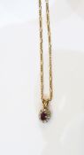 9ct gold, ruby and diamond cluster pendant on a 9ct gold chain, the oval central ruby 3mm x 5mm,