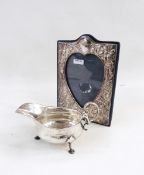 Modern silver photograph frame decorated with flowerhead around a central heart-shaped aperture