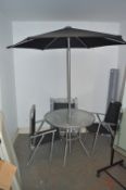 *Tubular Metal Garden Table with Four Folding Chairs and an Umbrella