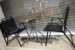 *Grey Tubular Metal Circular Garden Table with Three Black Mesh Folding Chairs and an Umbrella