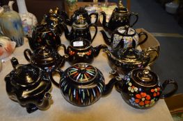 Collection of 12 Black Pottery Gilt & Floral Decorated Teapots