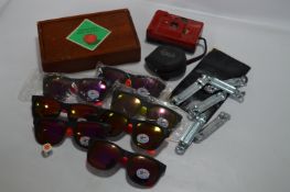 Seven Pairs of Sunglasses, Six Can Openers, Camera