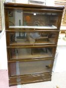 A GLOBE WERNICKE OAK STACKING BOOKCASE four section with glass sliding doors, shaped top and lower