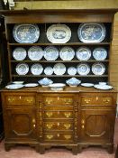 A NORTH WALES OAK BREAKFRONT DRESSER circa 1830 having a three shelf wide boarded rack over a