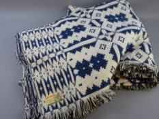 A LARGE WELSH WOOLLEN DOUBLE BEDSPREAD with original label, blue and cream reverse patterned, the