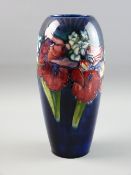 A MOORCROFT 'ORCHID & SPRING FLOWERS' VASE, 26 cms high, decorated on a cobalt blue ground,