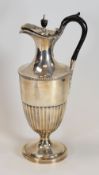A SILVER JUG of trumpet form with fluted body raised over a circular spreading foot and having an