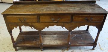 A NINETEENTH CENTURY WELSH OAK DRESSER BASE having an open platform base below three drawers and a