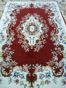 A 20th CENTURY HAND KNOTTED WOOLLEN CARPET probably Indian, with scattered floral pattern on a cream