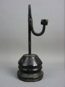 AN ANTIQUE IRON RUSH LIGHT NIP on a turned conical base, the nip arm with faceted weight, the base