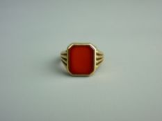 A FIFTEEN CARAT GOLD SIGNET RING with centre near square cut carnelian, 6.2 grms
