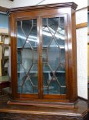 A GEORGIAN MAHOGANY WALL HANGING CORNER CUPBOARD with twin thirteen pane astragal glazed doors and