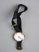 A LADY'S EDWARDIAN NINE CARAT GOLD CIRCULAR DIAL WRISTWATCH with black cloth strap