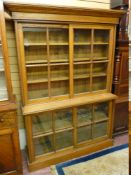 A CIRCA 1900 OAK BOOKCASE, the top section with inverted step cornice over twin glazed four panel