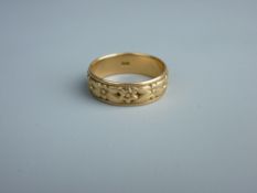 A FOURTEEN CARAT GOLD FLORAL PATTERNED WEDDING BAND, 7.4 grms