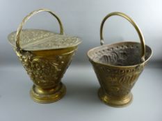 A TWIN LIDDED HELMET SHAPED REPOUSSE BRASS COAL SCUTTLE and one other, the former with date