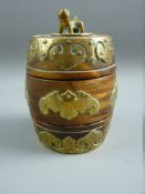 AN ORIENTAL HARDWOOD BARREL SHAPED CONTAINER in three parts with temple lion finial, central bat