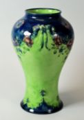 A MACINTYRE MOORCROFT BALUSTER VASE in a rare green and blue coloured reserves and with swags of