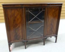 AN EDWARDIAN MAHOGANY BOOKCASE composed of flanking concealed cabinets and astragal glazed centre