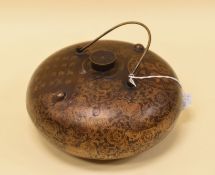 A CHINESE METALLIC HOT WATER BOTTLE button shaped with loop handle and screw-in cap, all-round
