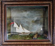 A MARITIME DIORAMA OF A SAILING YACHT in a cavity frame, the yacht with six sails and British